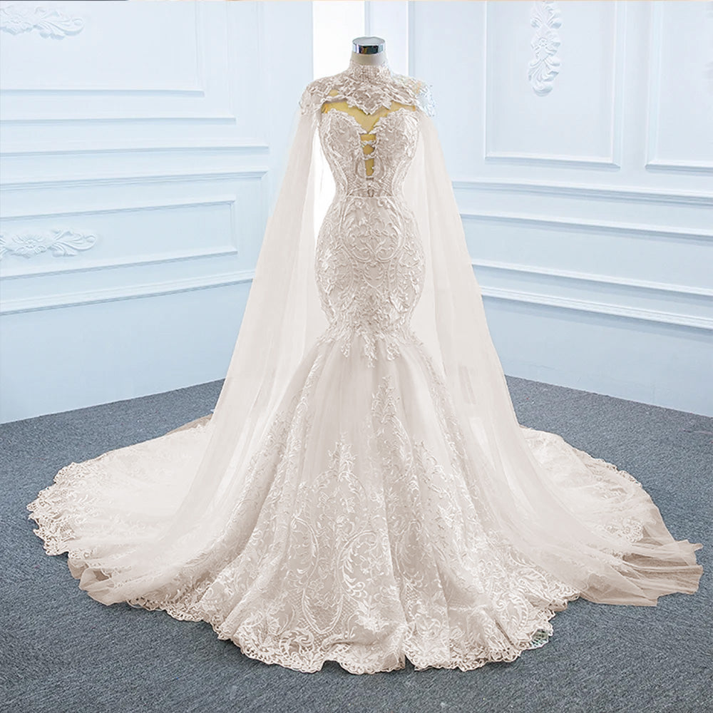Detailed close-up of the bridal shawl and bodice lace embellishments on an elegant off-the-shoulder mermaid wedding dress.