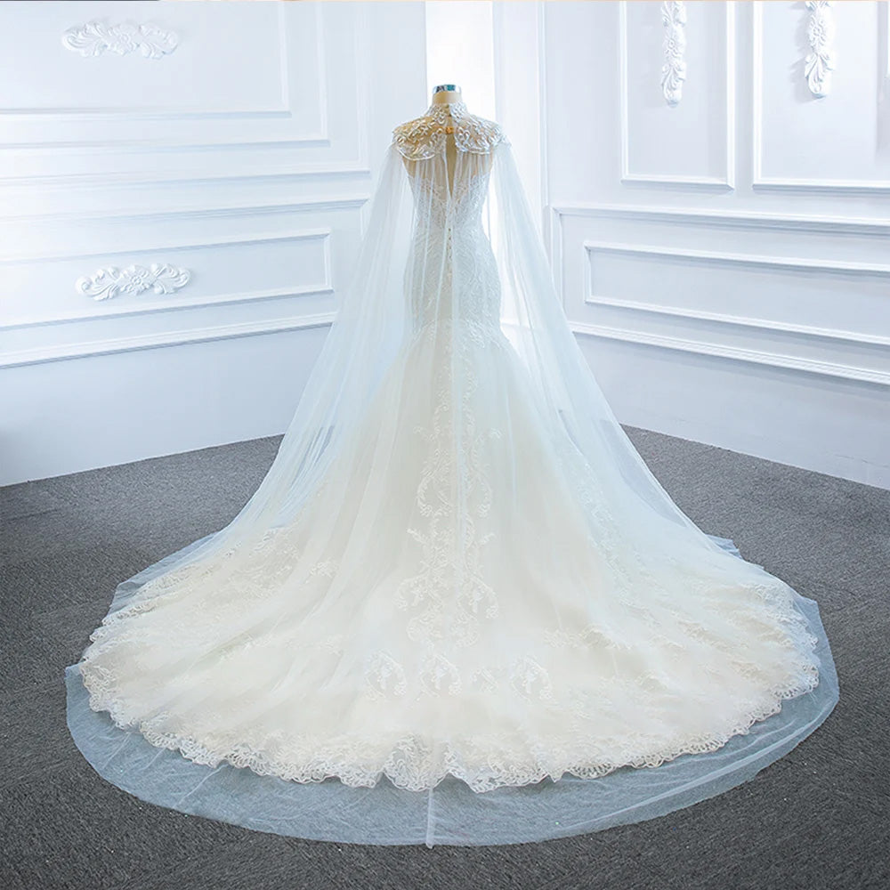 A studio portrait of a mermaid wedding dress and shawl displayed on a mannequin, perfect for a classic, sophisticated bridal aesthetic.