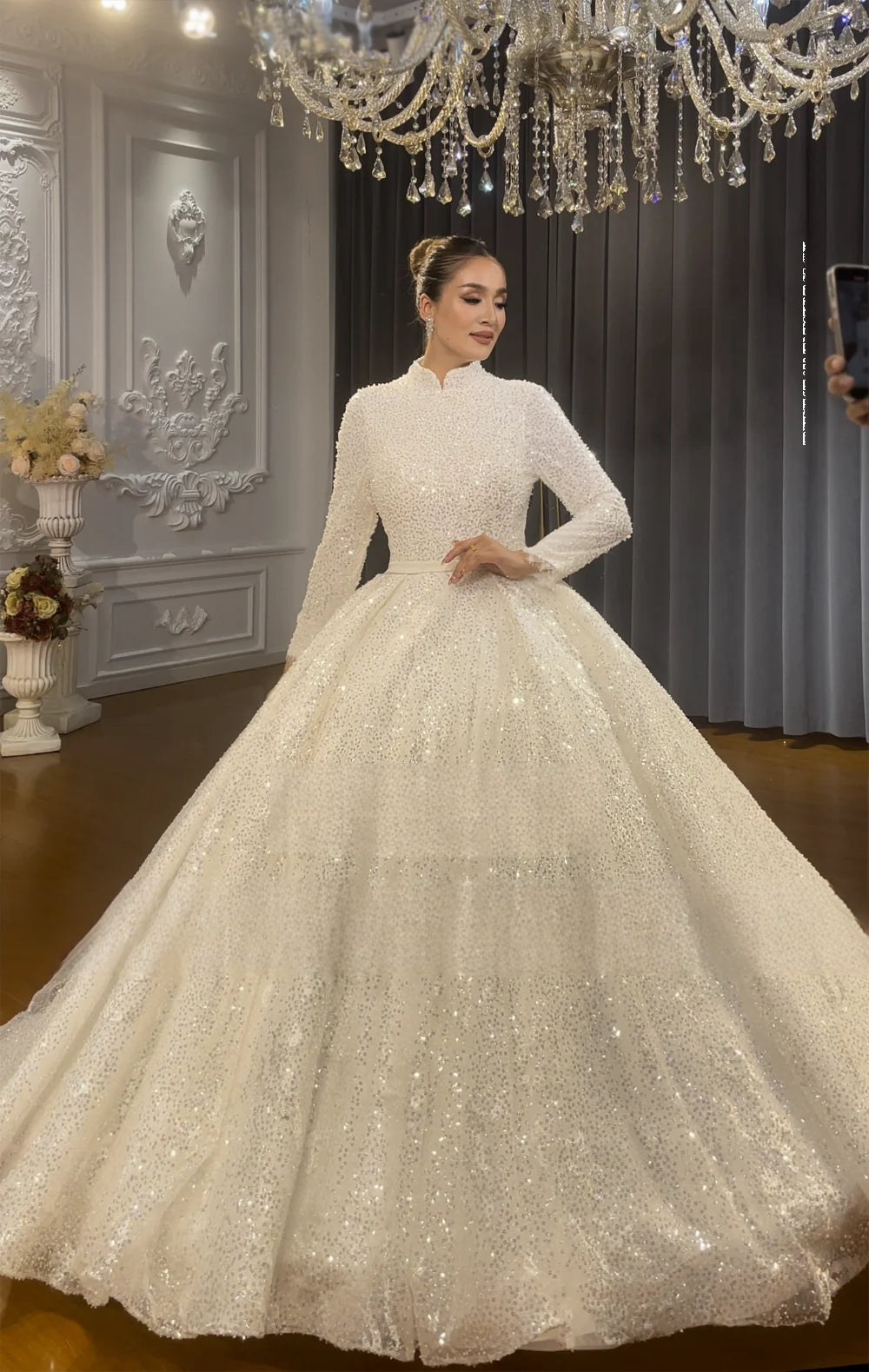 Close-up of the modest high-neck bodice on a shimmering long-sleeved Muslim wedding dress, showcasing intricate sequin and bead details.
