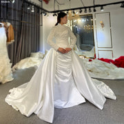 Front view of an elegant Muslim satin wedding dress featuring modest long beaded sleeves, a high neck, and a versatile 2-in-1 design with a detachable grand satin overskirt.