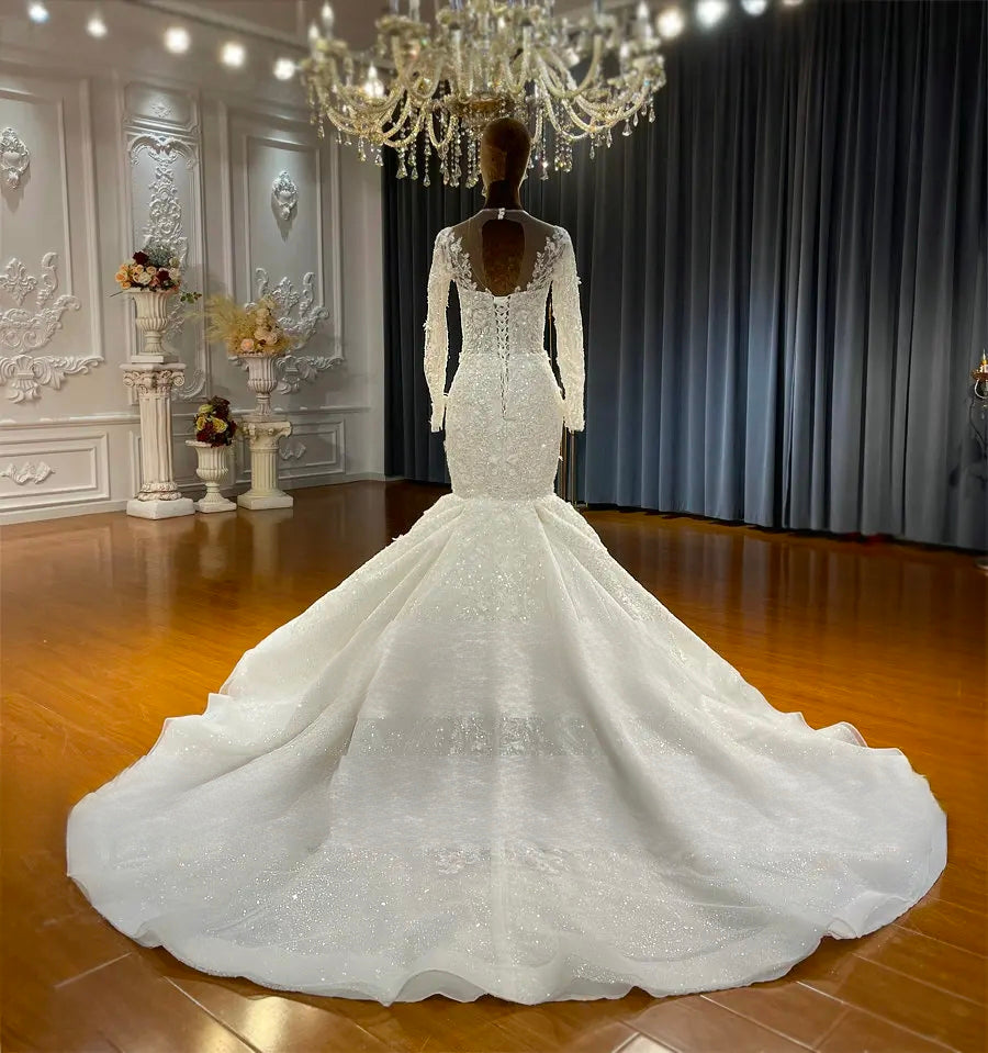 Rear view of a lace mermaid wedding dress highlighting the elegant keyhole back, traditional lace-up corset closure, and a sweeping romantic train.