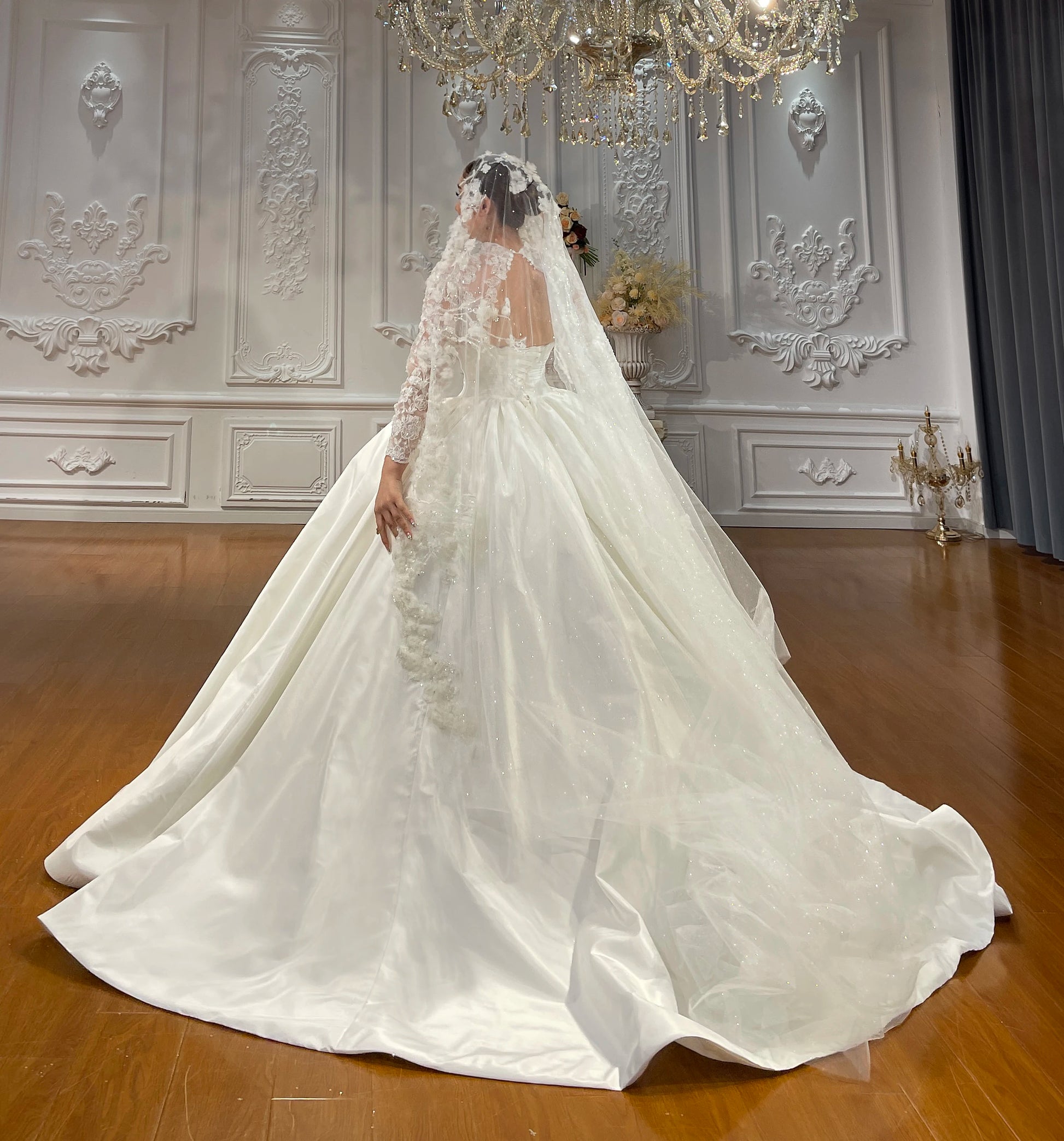 Side and back view of a timeless taffeta wedding dress highlighting the flowing train and a delicate cathedral-length lace veil.