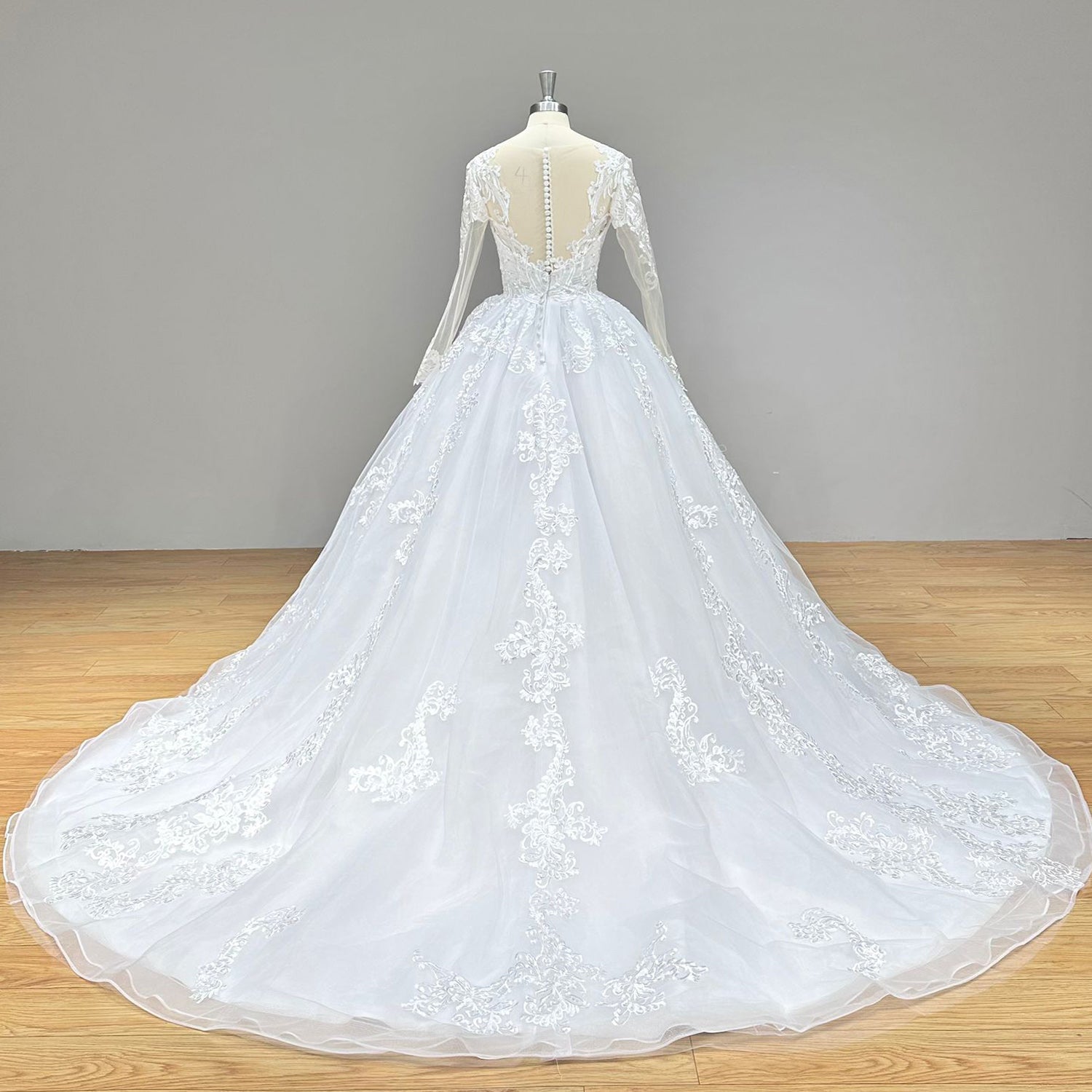 Dramatic full back view of an O-neck ball gown wedding dress on a mannequin, perfectly displaying the elegant illusion back and long, detailed train.