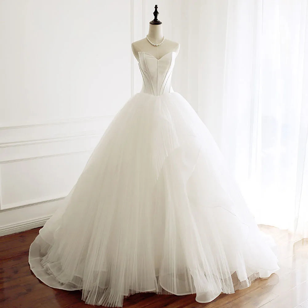 Elegant off-shoulder A-line wedding dress featuring a sweetheart neckline and a full, layered tulle skirt.