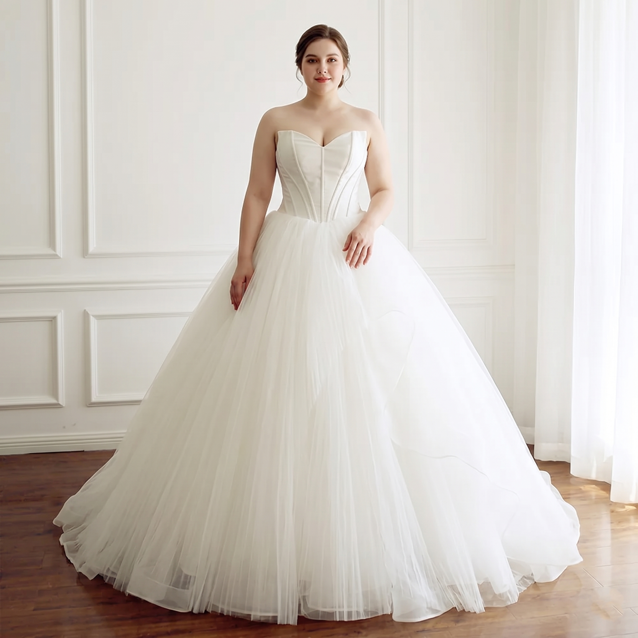 A stunning plus-size bride wearing a sleeveless A-line wedding gown with a structured sweetheart neckline and a full tulle skirt in a bright, minimalist studio.