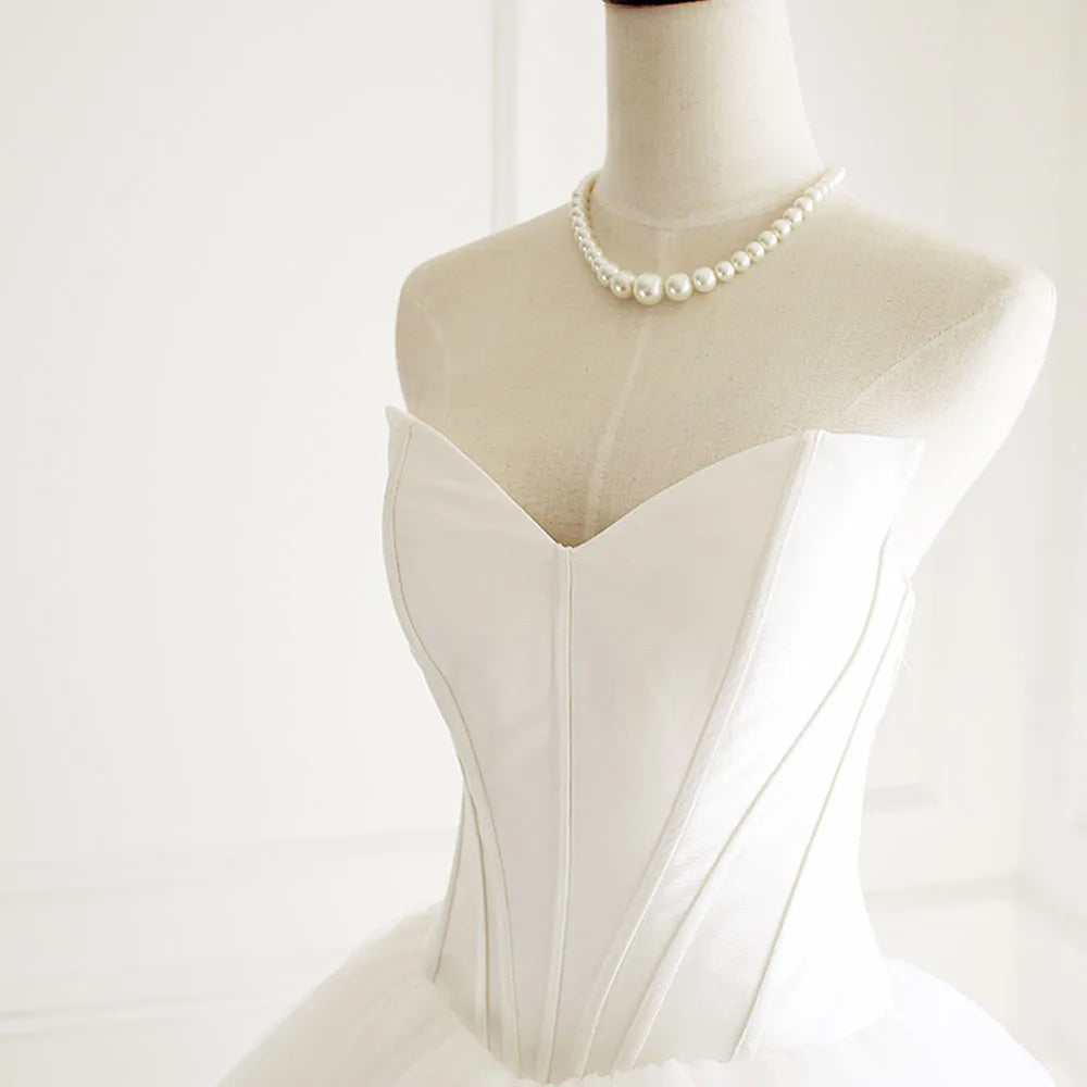 Close-up of the elegant sweetheart neckline and structured bodice of a sleeveless A-line wedding gown.