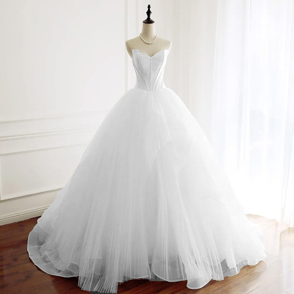 Full-length front view of a strapless A-line wedding dress with a structured sweetheart bodice and layered tulle skirt, displayed on a mannequin.
