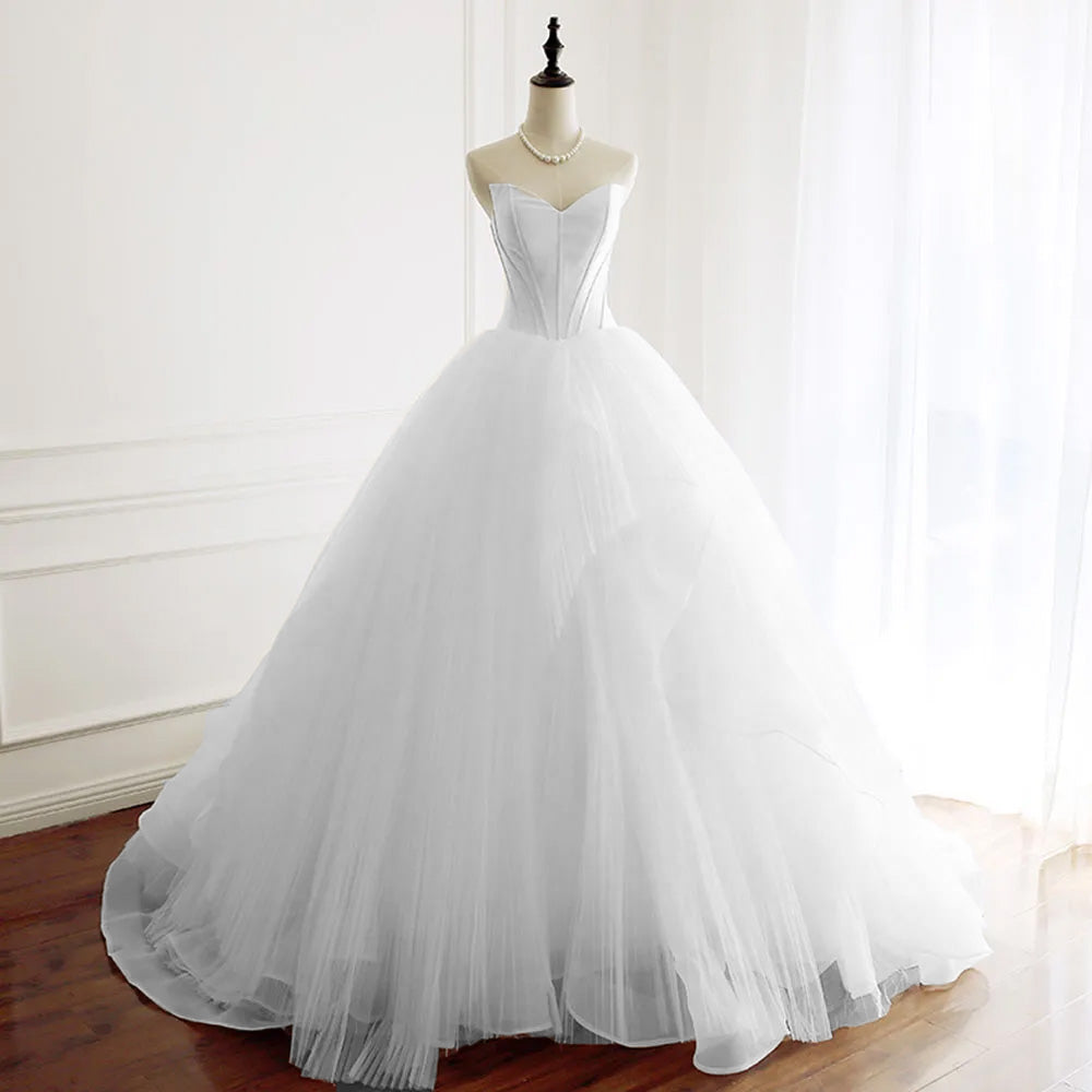 Full-length front view of a strapless A-line wedding dress with a structured sweetheart bodice and layered tulle skirt, displayed on a mannequin.