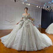 Full-length front view of an off-the-shoulder bridal gown featuring colorful sequin embroidery and a voluminous flowing skirt.
