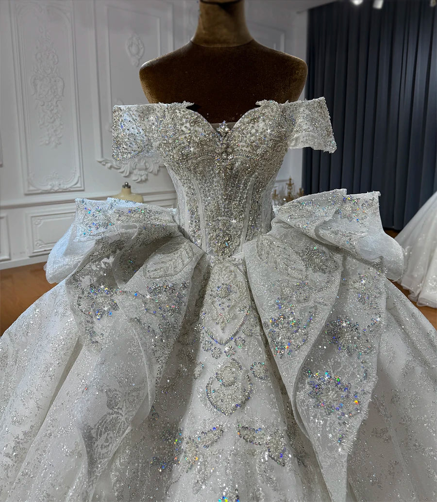 Close-up detail of a sequined wedding dress bodice with a sweetheart neckline and dramatic ruffled peplum accents at the waist.