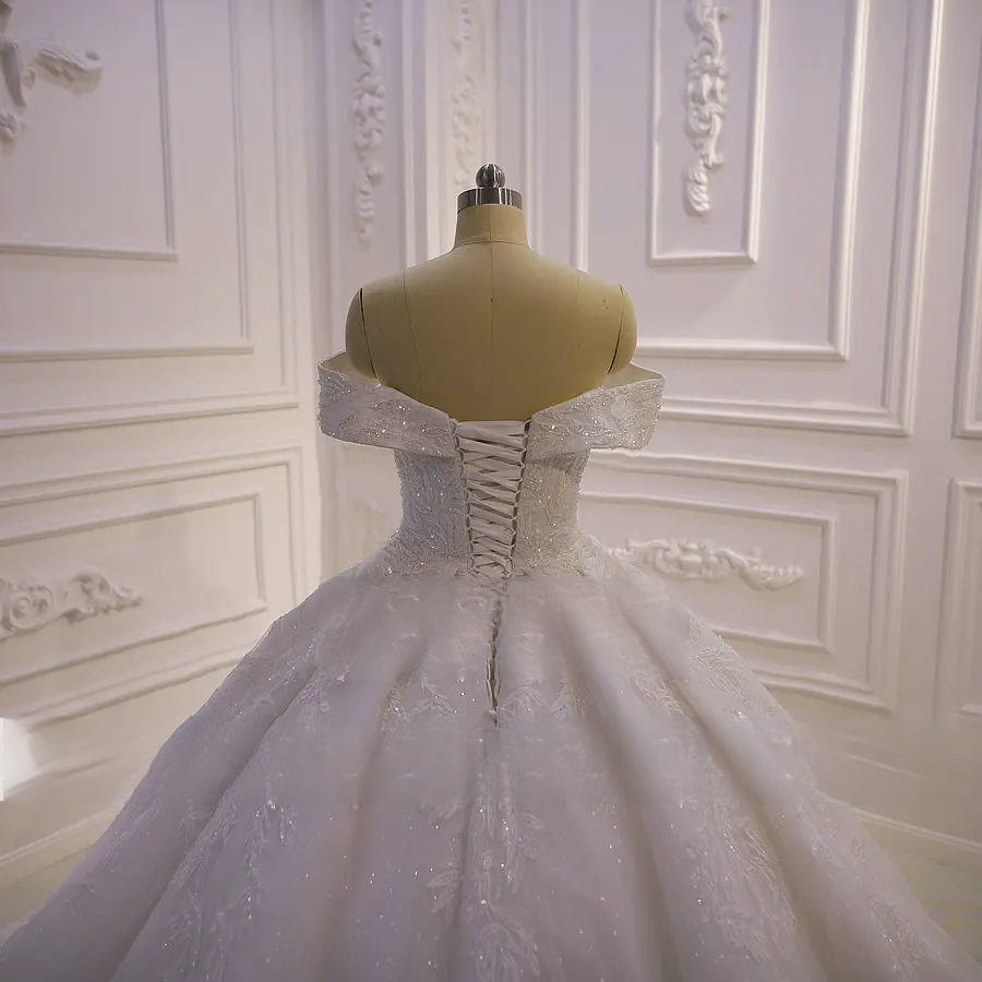 Detailed shot of a bridal gown bodice showcasing delicate off-shoulder straps and premium hand-beaded lace textures.
