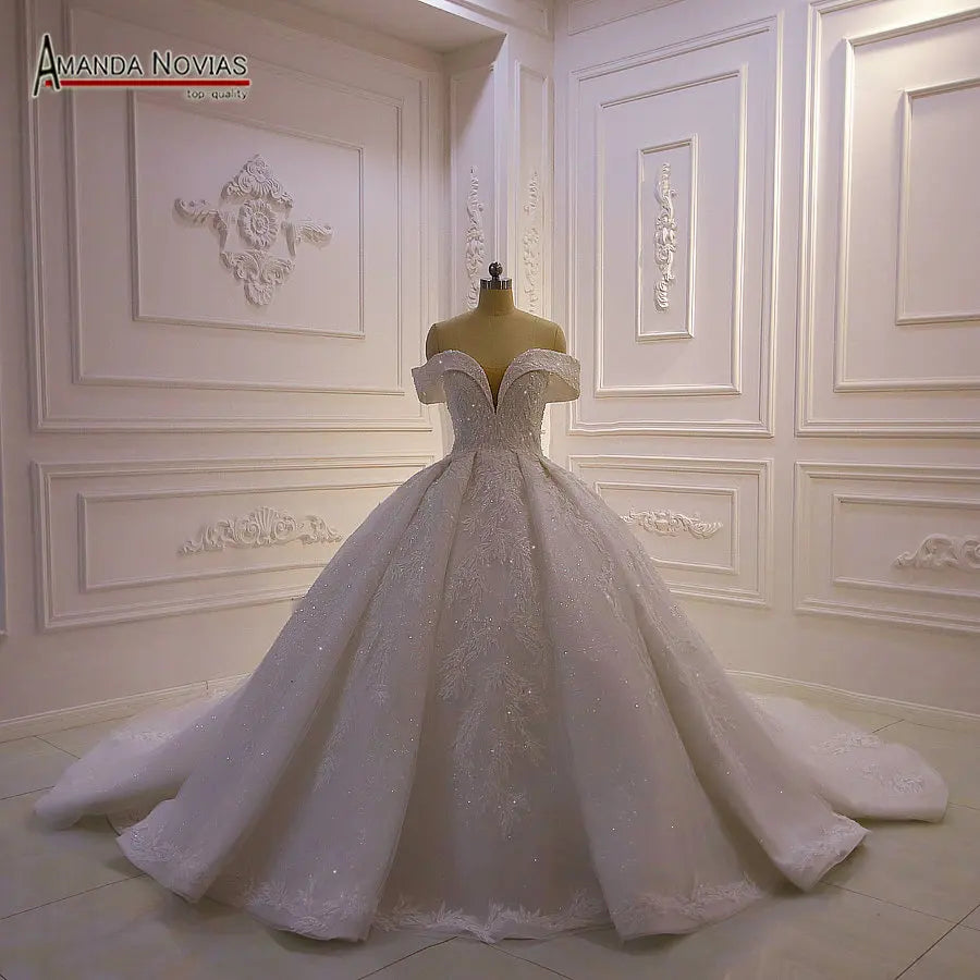 Full-length rear view of a luxury wedding gown emphasizing the dramatic floral vine lace trailing down a shimmering train.