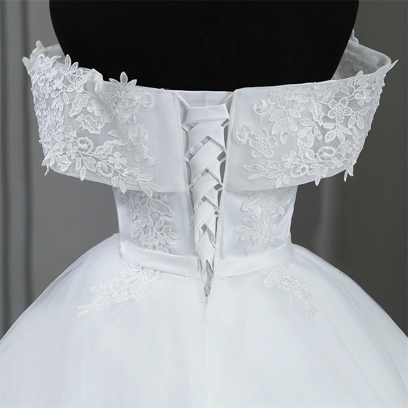Macro photograph highlighting the luxury texture of the embroidered floral lace, scattered pearl accents, and fine tailoring on the sweetheart bodice of the plus size wedding dress.