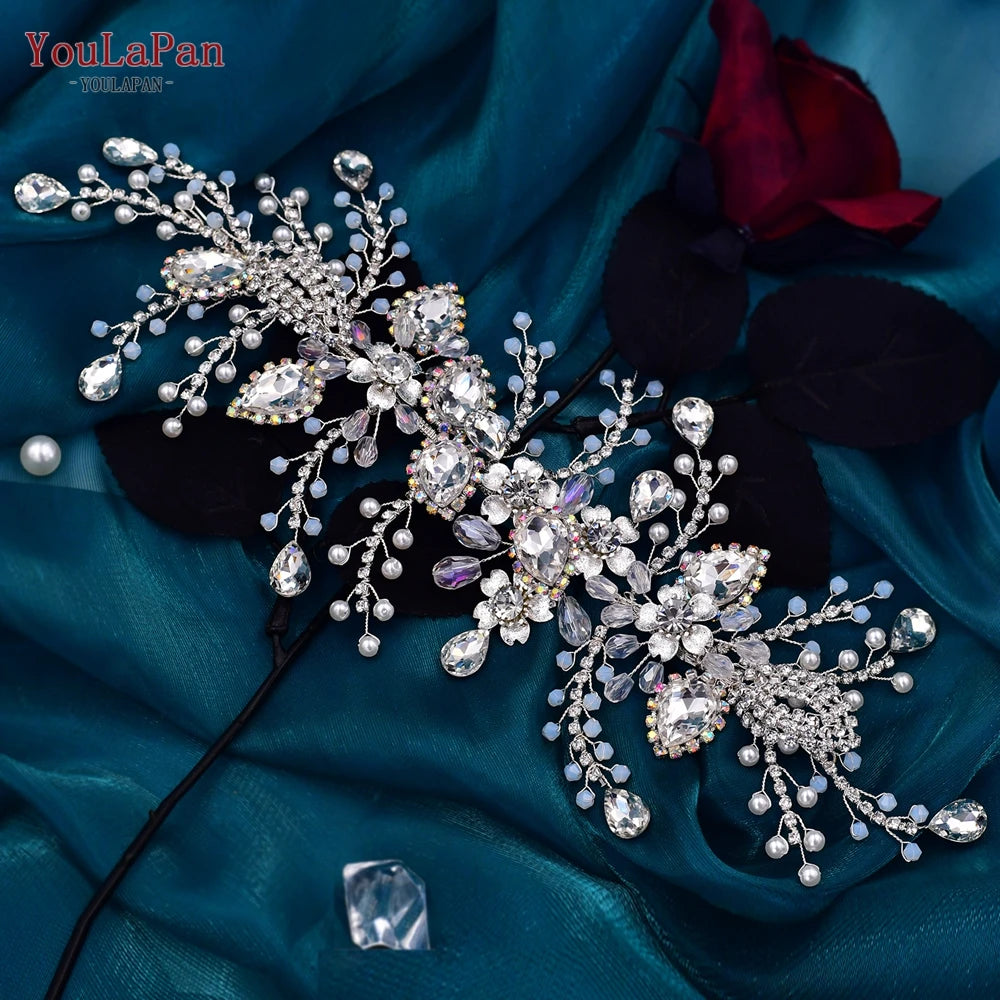 Top-down view of the silver crystal bridal hair vine piece styled over dark fabric with light blue crystal beads and central flower motifs.