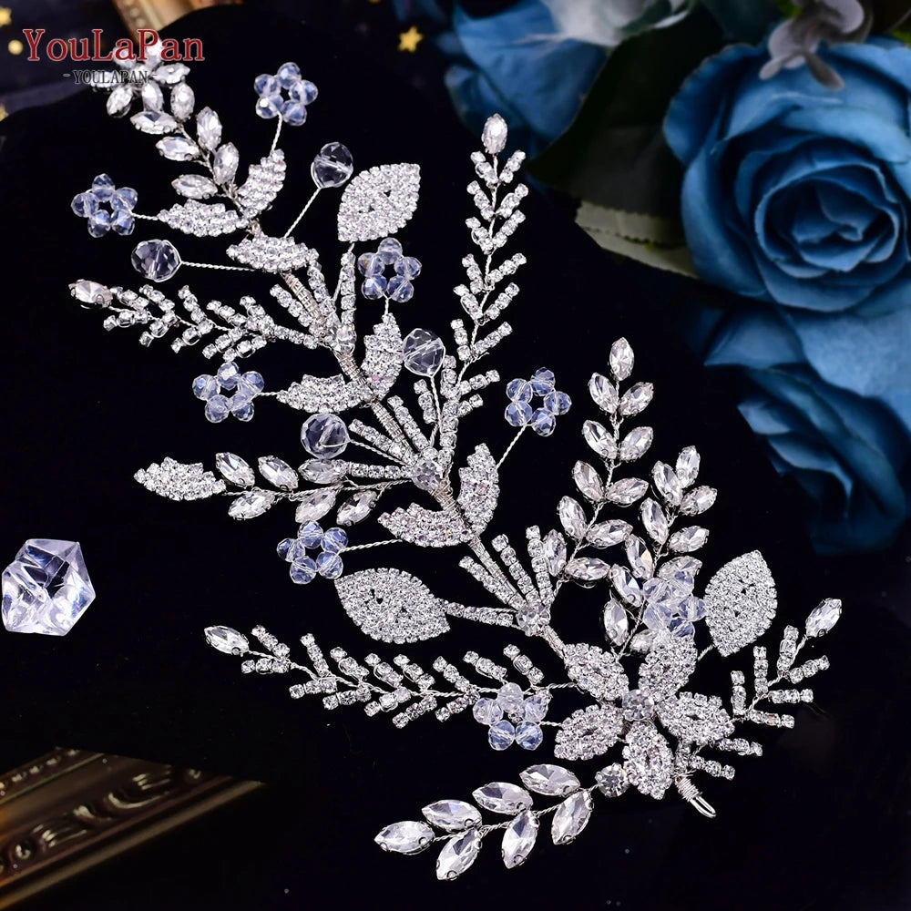 High-angle shot of a handcrafted silver bridal comb headpiece featuring shimmering clear rhinestones and small silver-plated leaf clusters on black velvet.