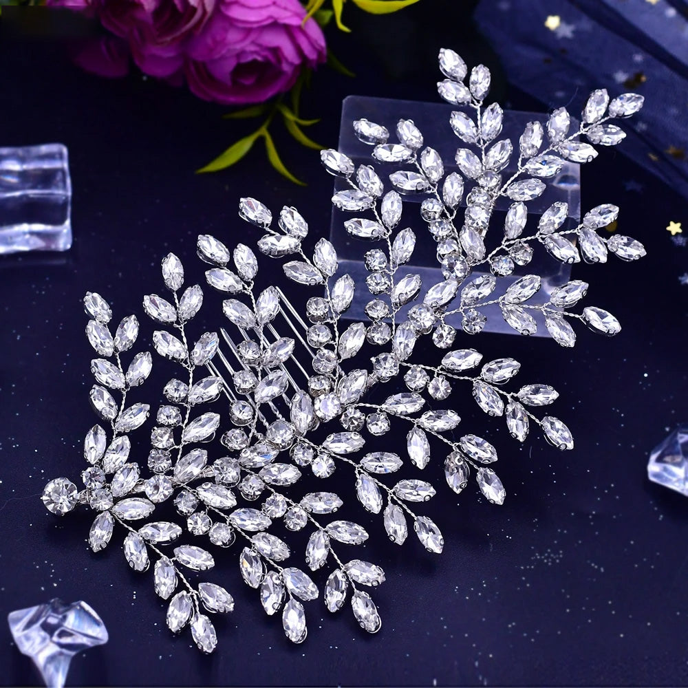 Direct overhead view of the elegant rhinestone bridal hair vine comb with marquise crystal leaf clusters, styled on a dark surface next to purple flowers.
