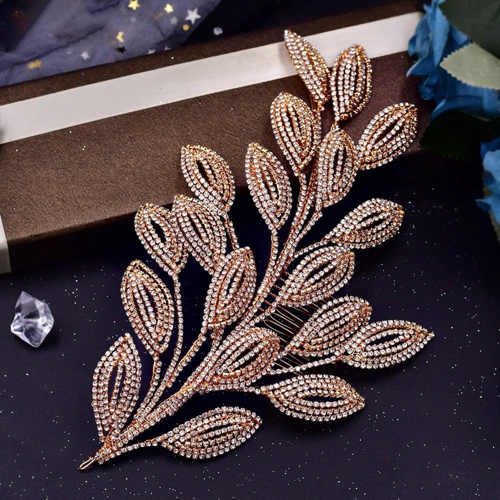 High-angle view of a vintage-style gold bridal hair comb headpiece with multi-tiered hollow leaf designs lined with miniature crystal rhinestones.