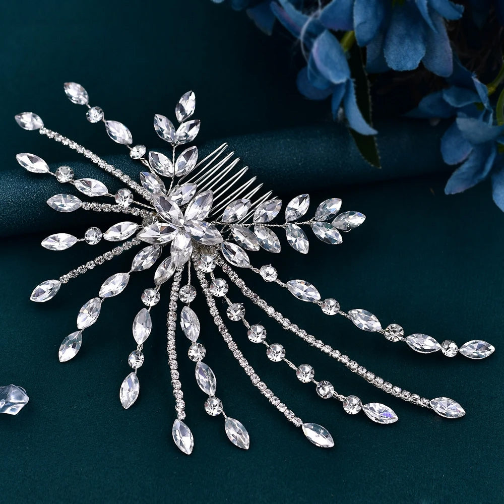 Handcrafted elegant wedding hair clip accessory featuring outstretched silver wire flower branches and dangling rhinestone tassels over dark teal silk.