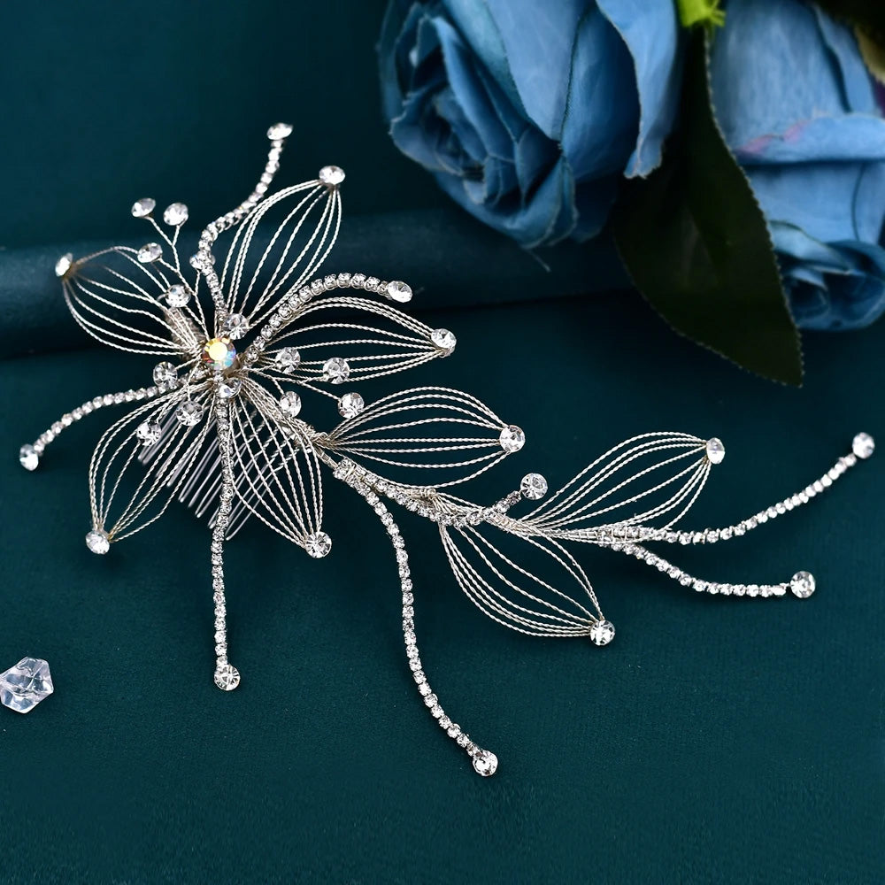 Wide overhead view of a large silver crystal bridal hair comb branch displaying widespread rhinestone sprigs and a central floral wire motif.