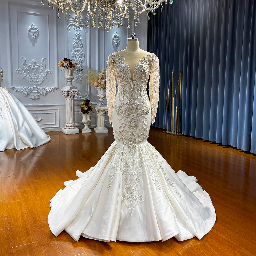 Front view of the satin mermaid bridal gown on a mannequin, highlighting the heavy lace embroidery and the smooth transition to a structured satin skirt.
