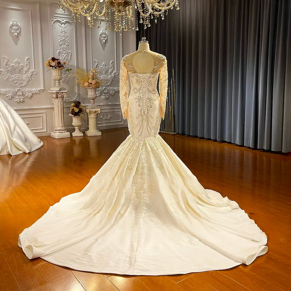Detailed close-up of the wedding dress bodice, focusing on the luxury pearl and crystal beadwork, sweetheart neckline, and delicate off-the-shoulder lace straps.