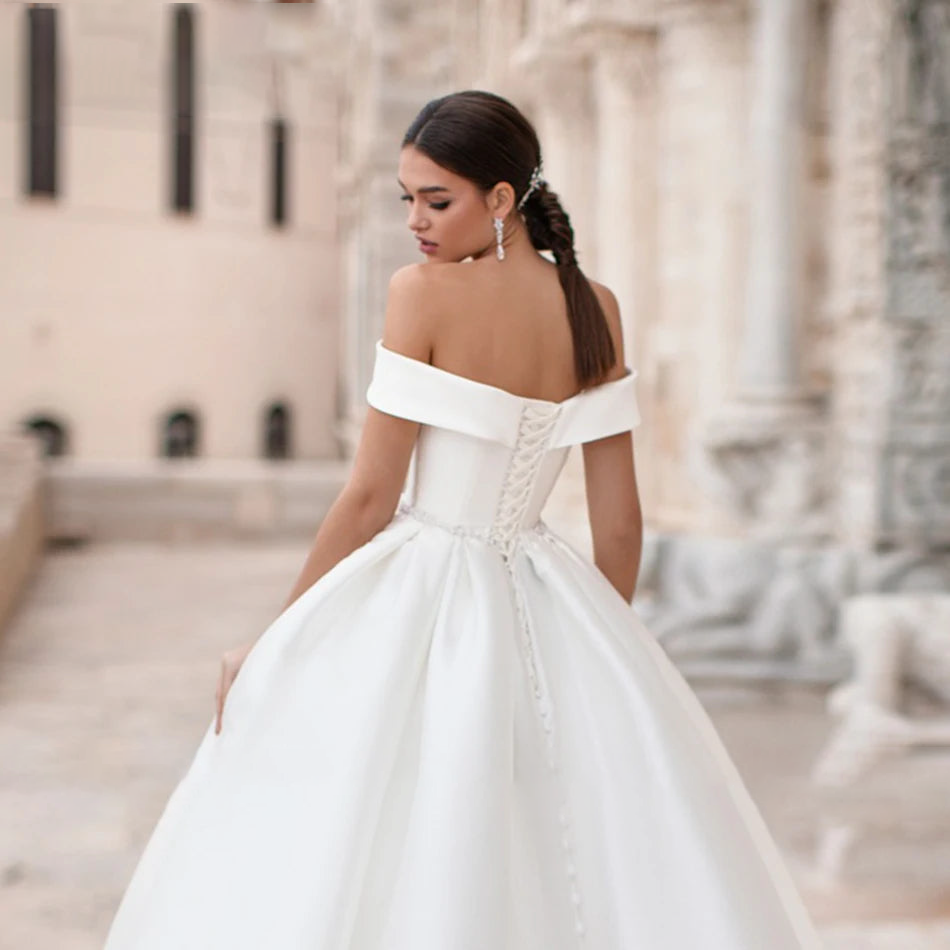 Back view of the princess wedding gown, highlighting the intricate lace-up corset detail and a classic long train.