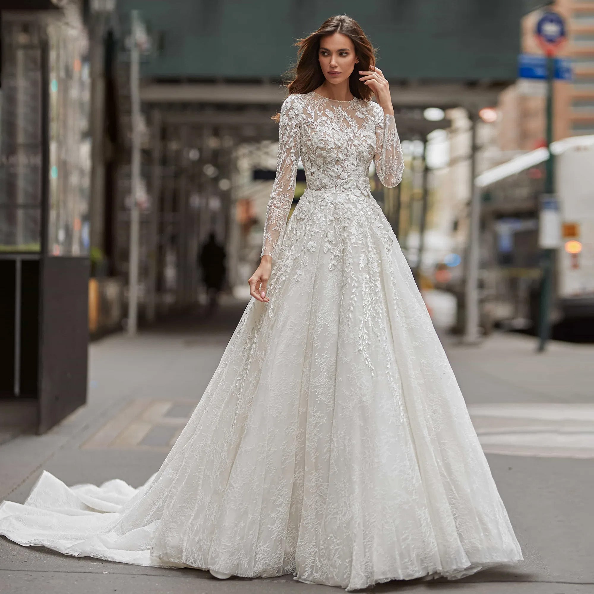 Elegant sequined A-line wedding dress with long sleeves, showcasing a flowing silhouette in an urban street setting.