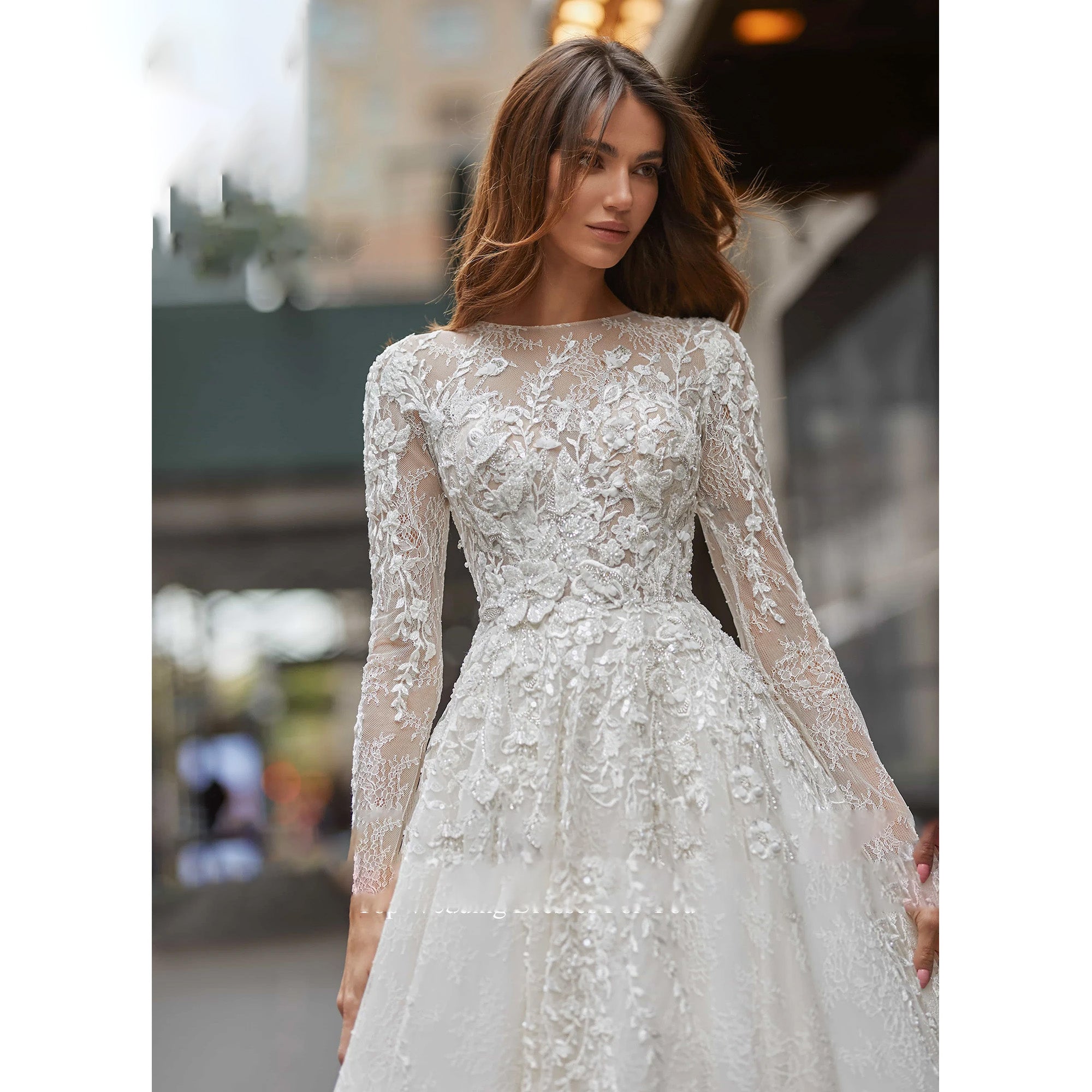 Close-up of an elegant sequined wedding dress bodice with long sleeves and delicate lace embroidery.