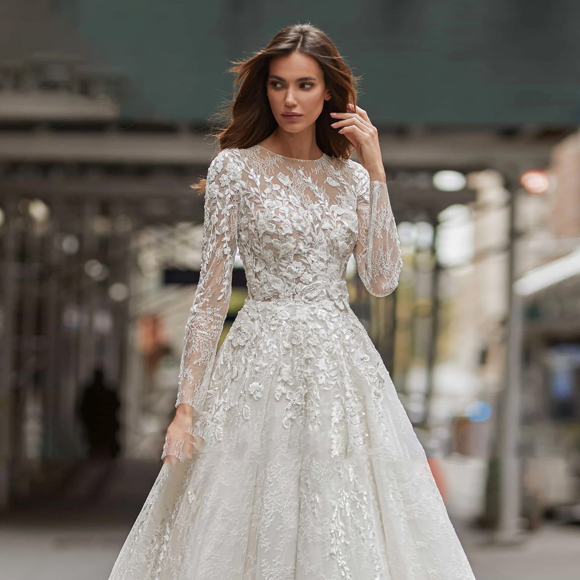 Detailed view of an elegant sequined long-sleeve A-line wedding dress, highlighting the shimmering fabric texture