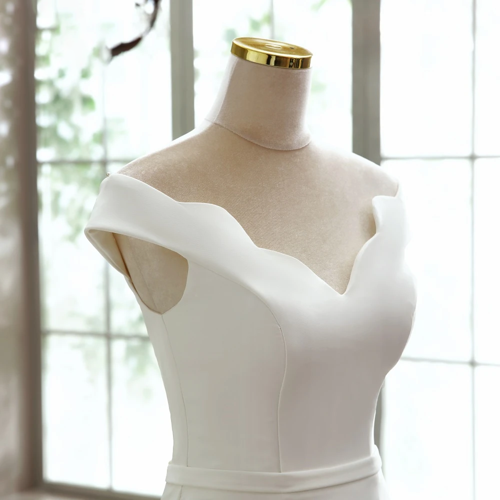 A close-up front view of the minimalist boat neck detail on an elegant mermaid wedding gown.