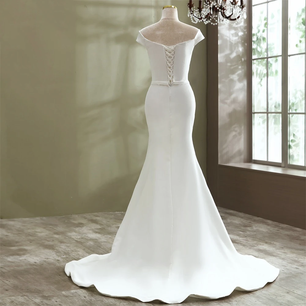 mannequin showcasing the back view of a simple, elegant boat neck mermaid bridal gown with a subtle, clean design.