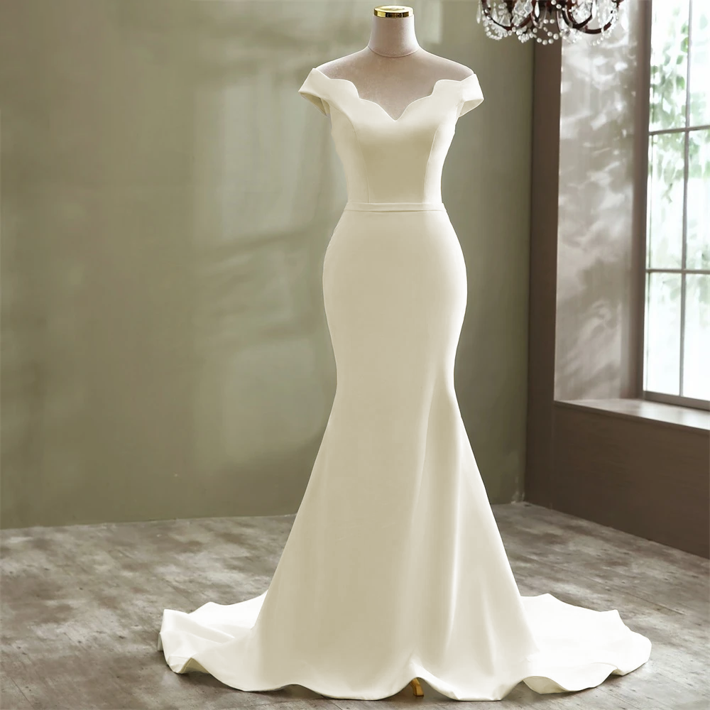 A mannequin display of a simple and elegant boat neck mermaid wedding dress in a minimalist style, ideal for a modern bridal look.