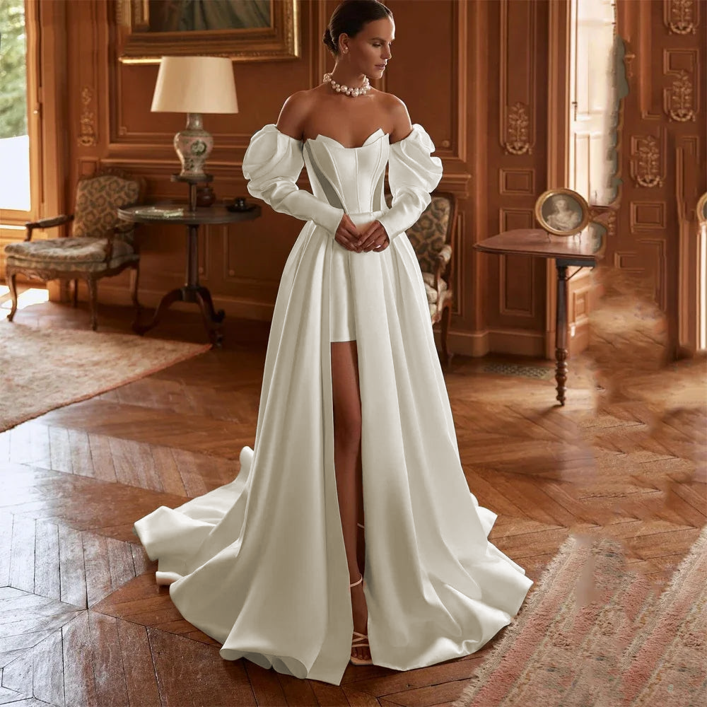 A bride standing in an elegant interior wearing a high-fork A-line satin wedding dress with puffed off-the-shoulder sleeves and a flowing skirt.