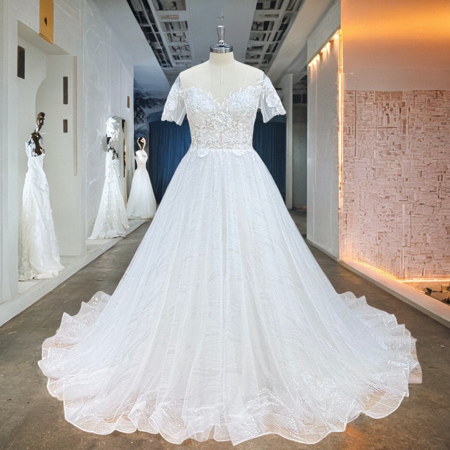 Full-length front view of a sequined white A-line wedding dress with short sleeves and a scalloped hem train on a boutique mannequin.