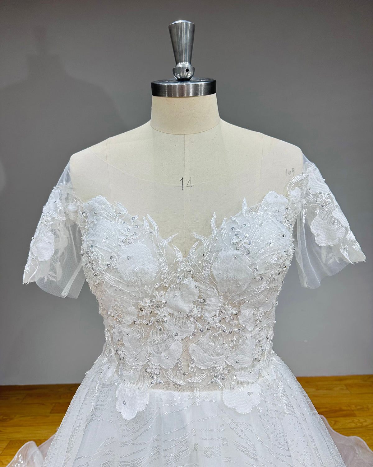 Close-up front view of the bridal gown bodice highlighting the sweetheart neckline, sheer illusion straps, and silver sequin lace embellishments.