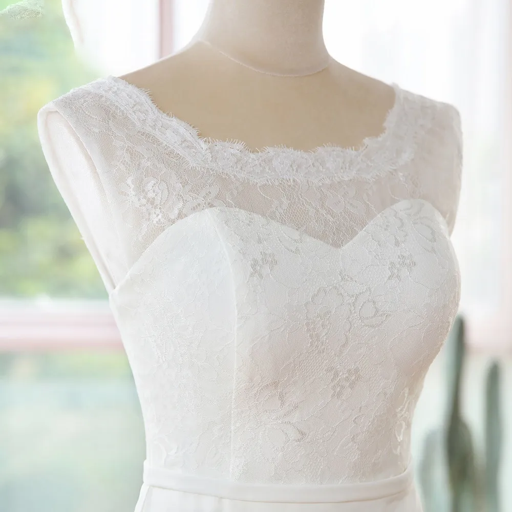 Detailed close-up of the delicate lace neckline and bodice detailing on a simple sleeveless mermaid wedding dress.