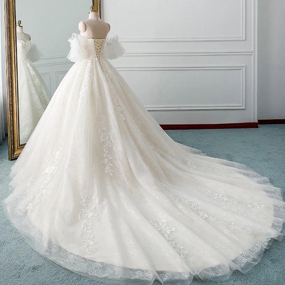 Back view of an elegant A-line bridal dress with a lace-up corset back and detachable tulle sleeves.