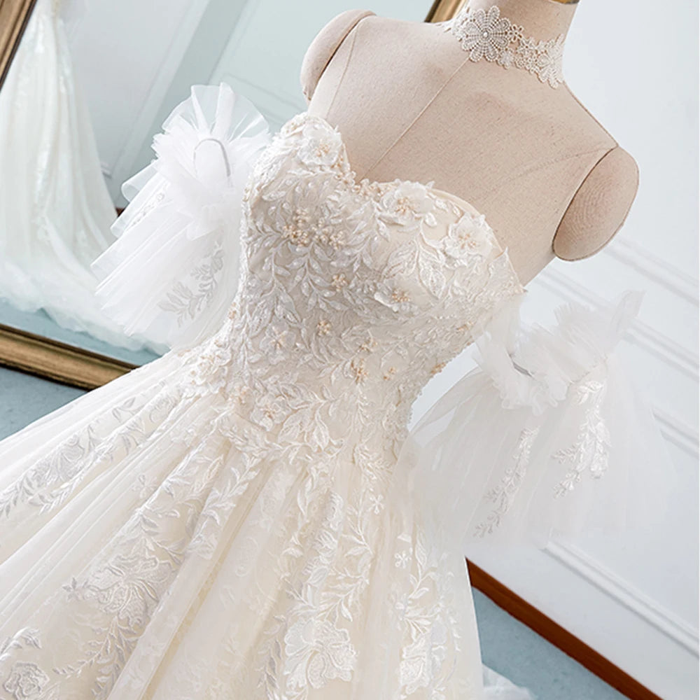 Rear detail of an A-line wedding dress showing the corset back lacing and detachable tulle sleeves.