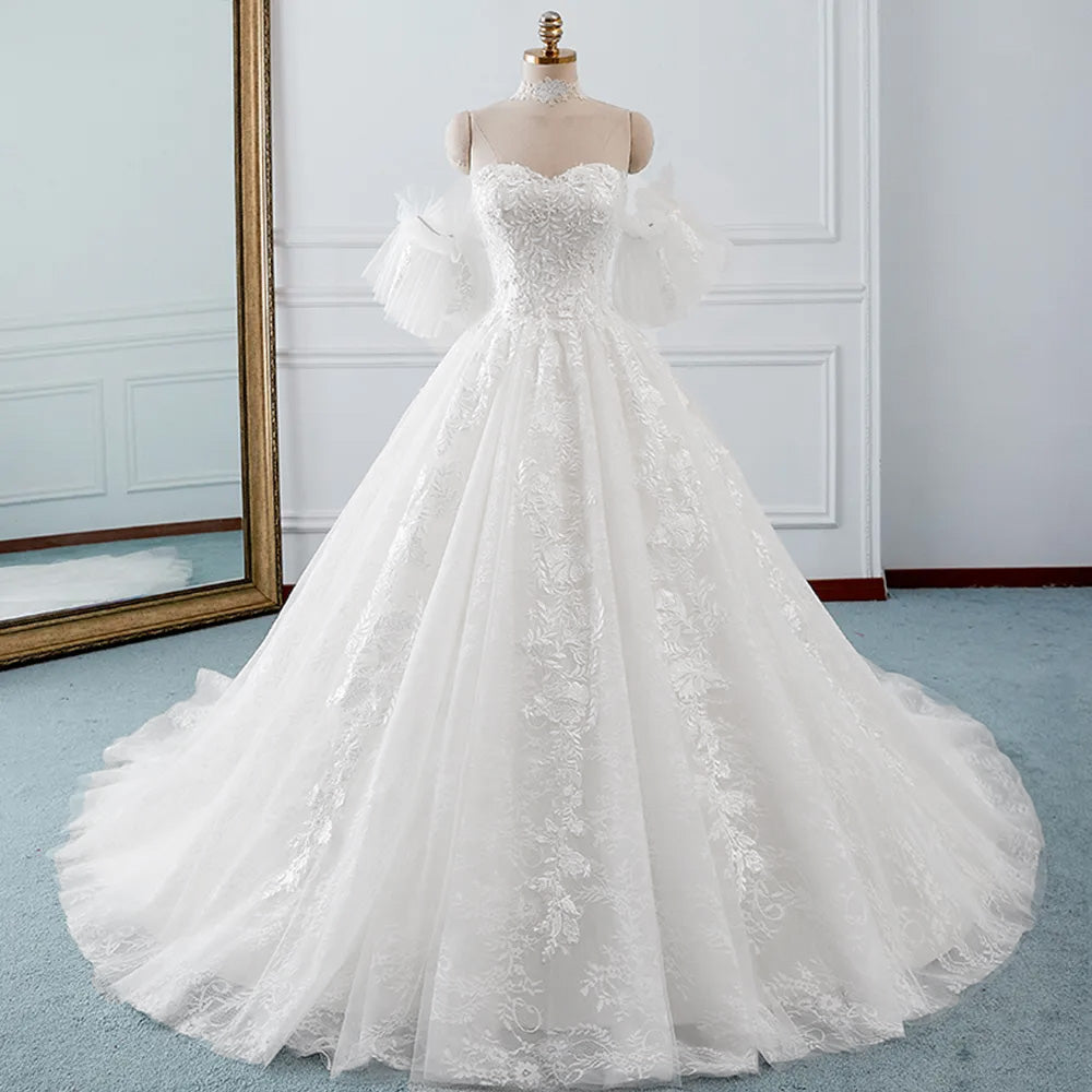 A gorgeous A-line bridal gown with a sweetheart neckline, delicate lace appliques, and stylish detachable ruffled sleeves.