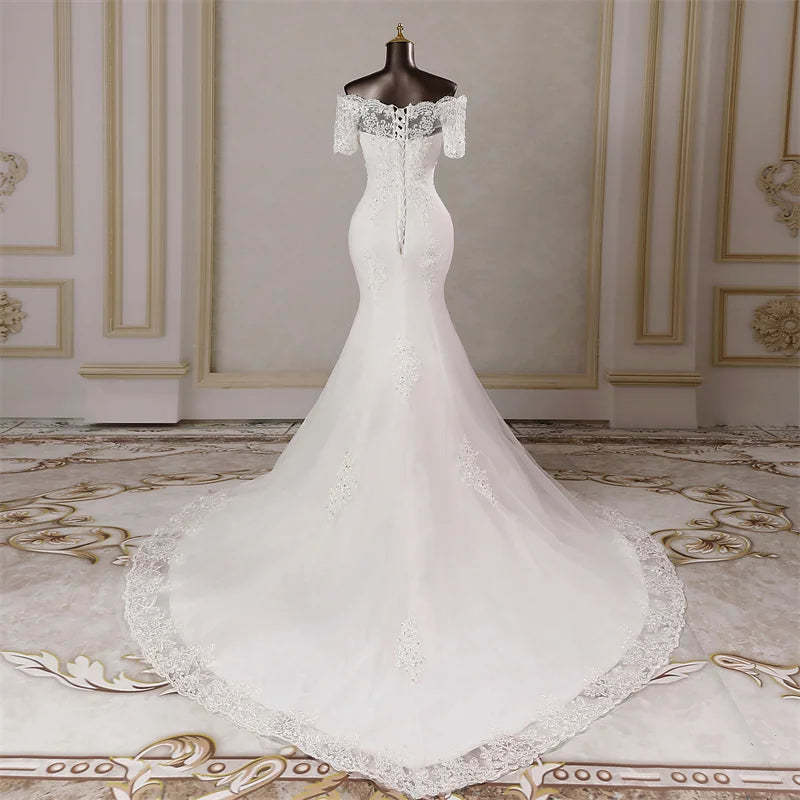 Rear view of an elegant mermaid wedding dress on a mannequin, featuring a sophisticated lace-up corset back and a flowing train.