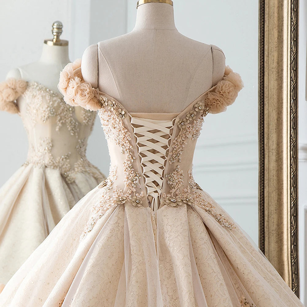 Rear detail shot of a ball gown wedding dress bodice, showcasing the adjustable lace-up corset back and floral sleeve accents.