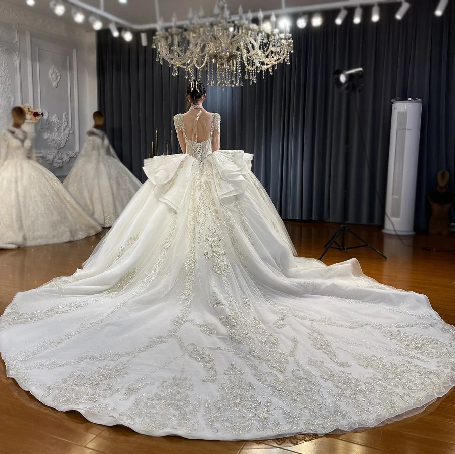 Detailed macro shot of the cascading tiered organza ruffles and shimmering fabric on the back of a royal ball gown bridal dress.