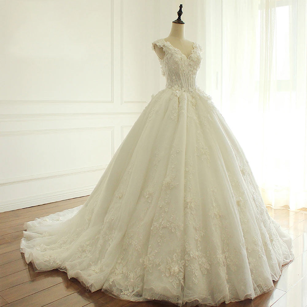 A professional bridal boutique display of an A-line wedding gown, featuring a V-neckline, intricate floral lace detailing, and a full, elegant skirt on a mannequin.