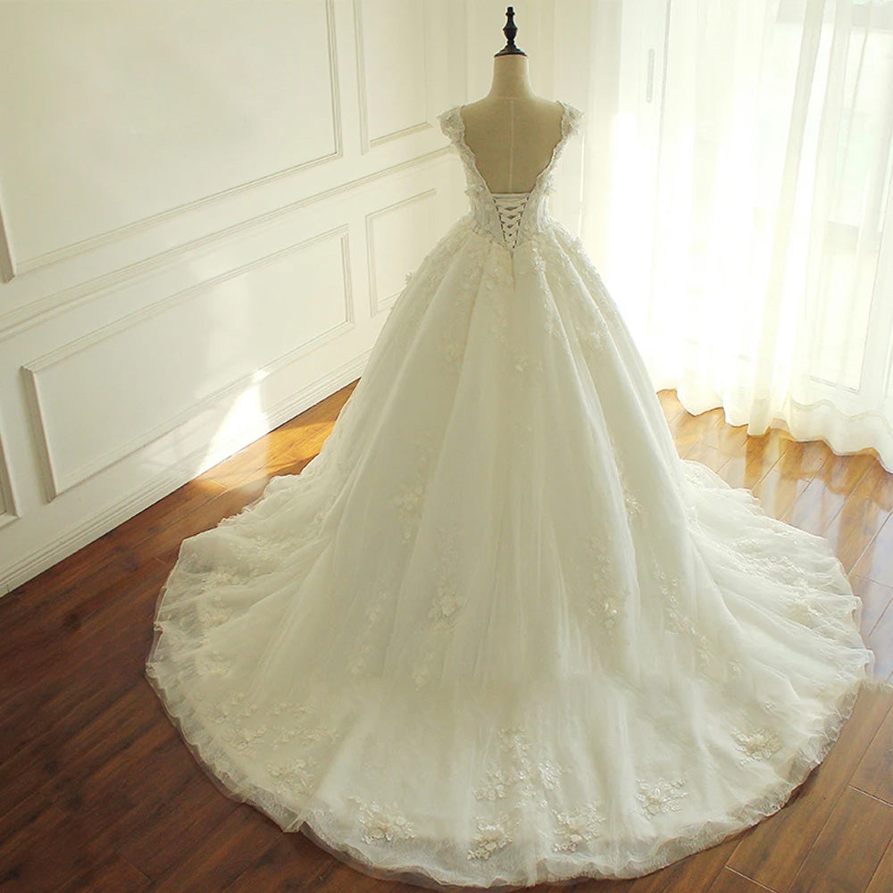 A bridal mannequin showcasing an elegant A-line princess wedding dress with a V-neckline, floral appliques, and a structured, sophisticated design.