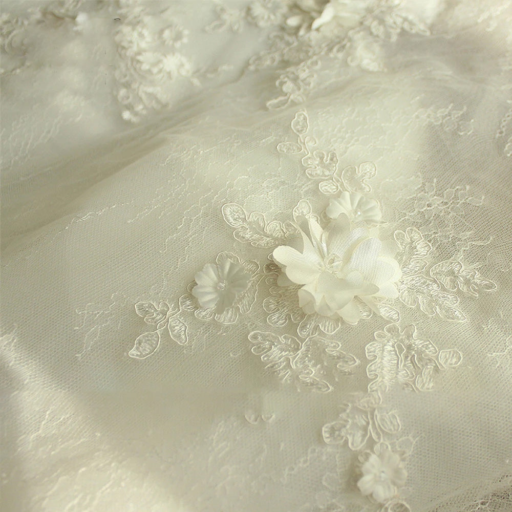 Close-up view of a bridal mannequin wearing an A-line wedding dress, focusing on the intricate V-neckline and delicate floral lace appliques.
