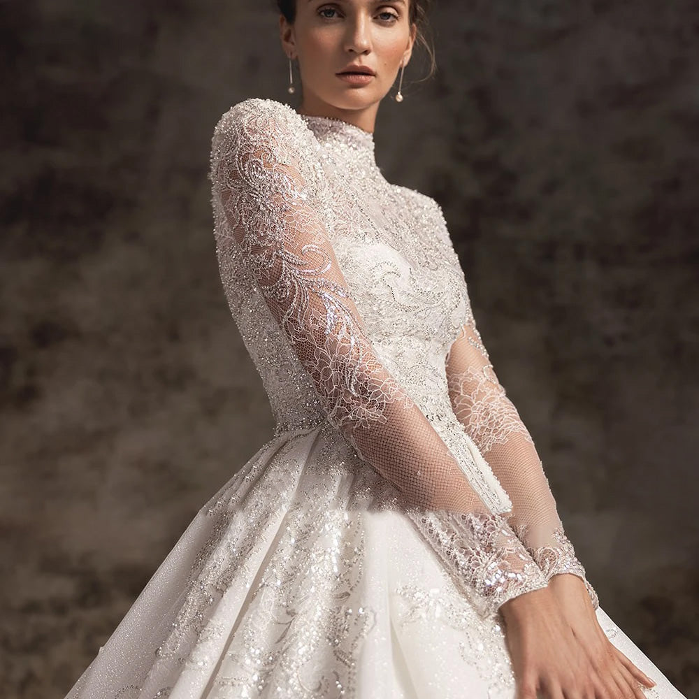 A professional product shot of an A-line wedding dress, focusing on the lace bodice and voluminous tulle skirt with a royal train.