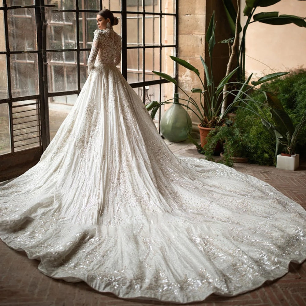 Rear view of an elegant lace wedding dress showcasing a fitted bodice, long sleeves, and an expansive, detailed bridal train.