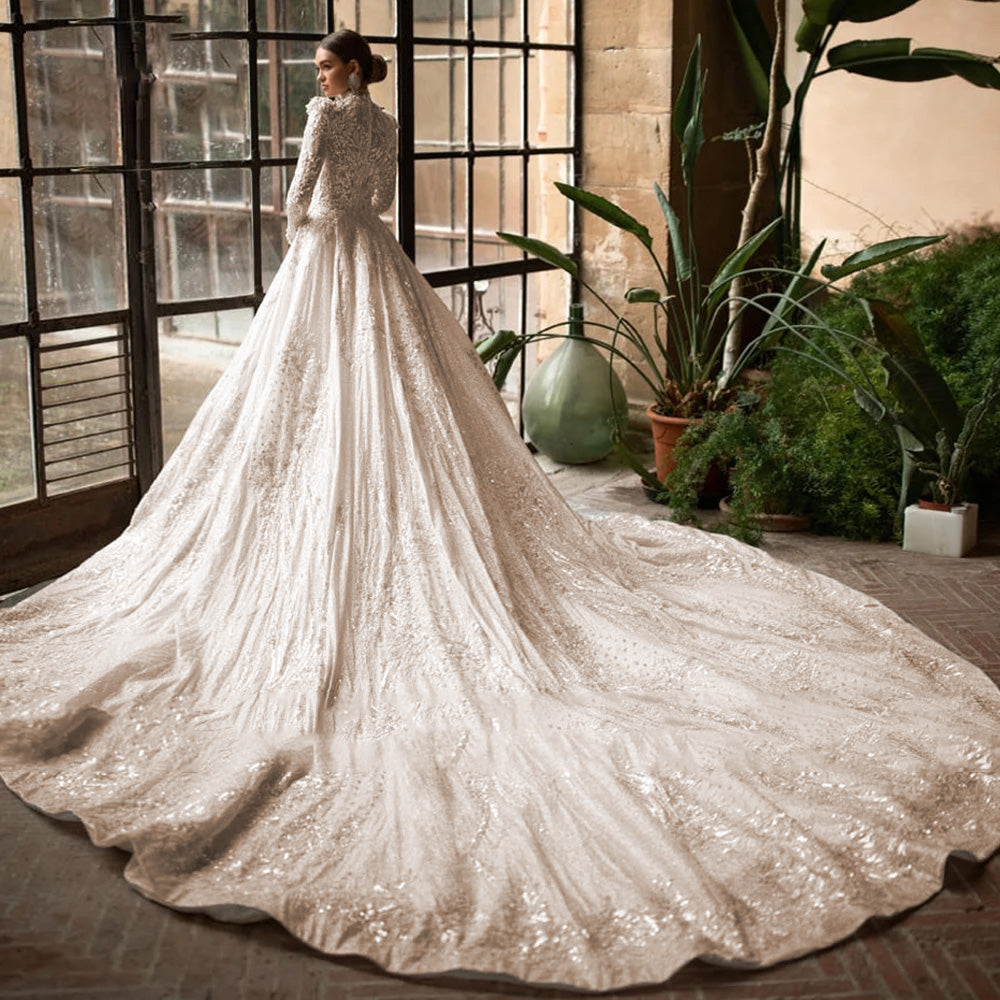 Full-length view of a vintage-style A-line wedding gown with a grand court train, posed gracefully by a large window.