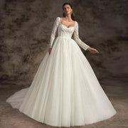 Full-length view of a bride wearing a sexy backless V-neck wedding dress with elegant lace appliques, intricate flowers, and a long chapel train.