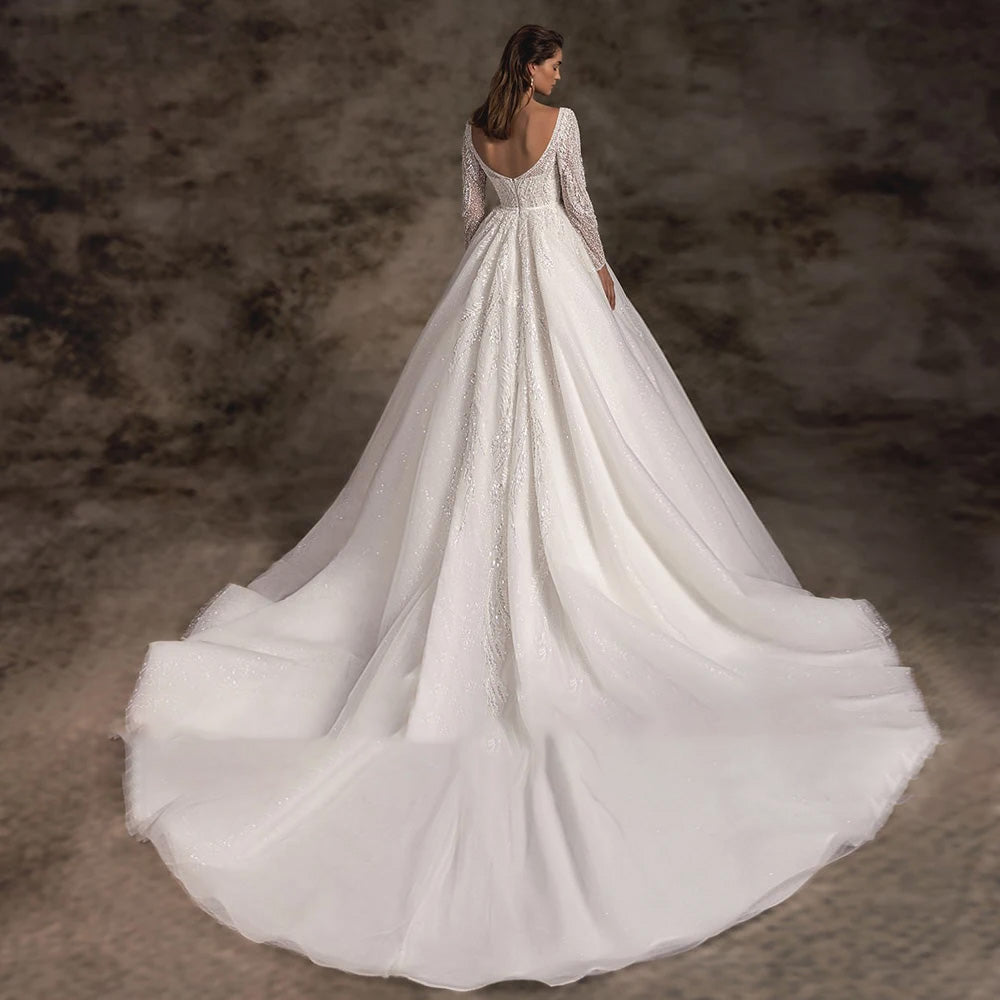 The back view of an elegant lace A-line bridal gown with a sexy backless design and a long, detailed chapel train.